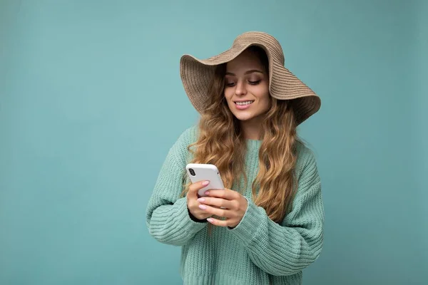 Mulher bonita vestindo roupas casuais de pé isolado sobre o fundo de surf na internet via telefone olhando para a tela móvel — Fotografia de Stock