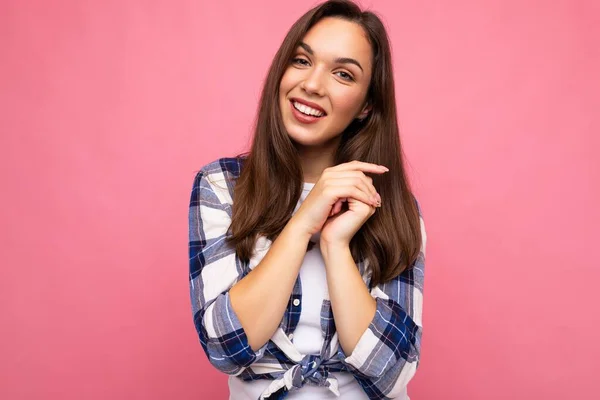 Фото молодой позитивной восхитительной сексуальной улыбающейся красивой брюнетки с искренними эмоциями в модной чековой рубашке, изолированной на розовом фоне с пустым пространством — стоковое фото