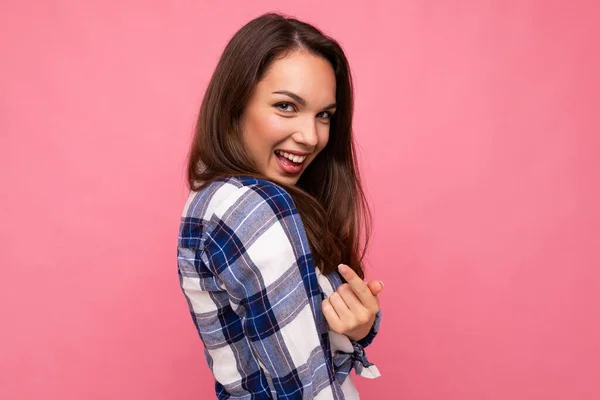 Foto portret van jonge mooie glimlachende hippe brunette vrouw in trendy blauw en wit shirt. Sexy zorgeloze vrouwelijke persoon poseren geïsoleerd in de buurt van roze muur met lege ruimte in de studio. Positief model — Stockfoto