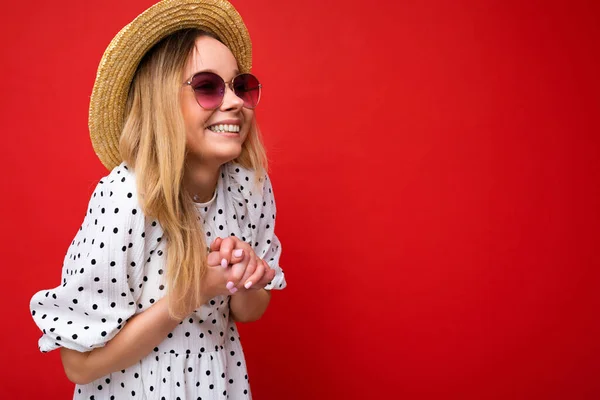 Foto de atractiva mujer rubia sonriente feliz usando ropa casual de verano y gafas de sol con estilo aisladas sobre la pared de fondo colorido mirando a un lado — Foto de Stock