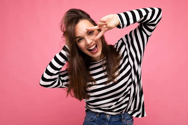 Foto van jong europees positief glimlachen winderig vrolijk gelukkig mooi brunette vrouw met oprechte emoties dragen casual gestreepte trui geïsoleerd op roze achtergrond met kopieerruimte — Stockfoto