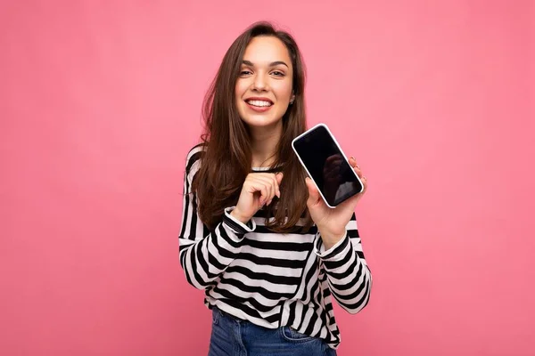 웃으며 웃고 있는 성인 여성 이 줄무늬 스웨터를 입고 있는 모습 이 카메라 화면을 통해 핸드폰 화면을 보고 있는 모습 이 배경에 고립되어 있다. — 스톡 사진