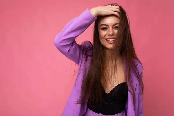 Portrét pozitivní nádherné krásné módní brunetky žena v ležérní módní fialové bundy izolované na růžovém pozadí s volným prostorem — Stock fotografie