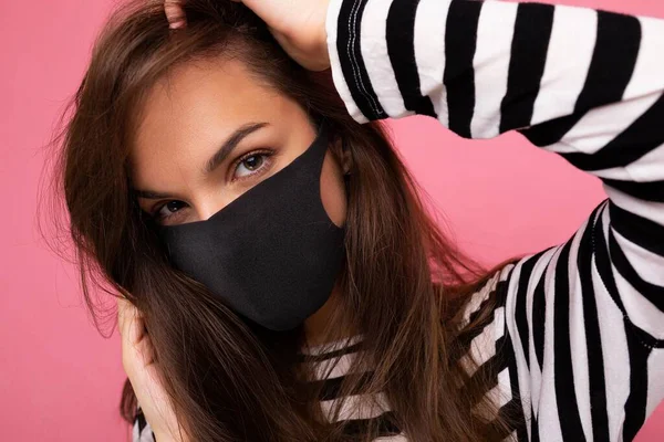 Closeup portrait of young attractive brunet woman in mediacal face mask isolated over background wall. Protection against COVID-19 — Stock Photo, Image