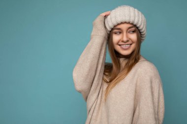 Güzel, pozitif, mutlu, esmer, sarışın bir kadın renkli arka plan duvarından izole edilmiş, günlük tarz kıyafetler giymiş, samimi duygular besliyor.