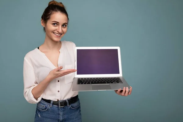 Fotografie a unei femei tinere frumoase care deține laptop-ul computerului uitându-se la camera izolată pe fundal colorat — Fotografie, imagine de stoc