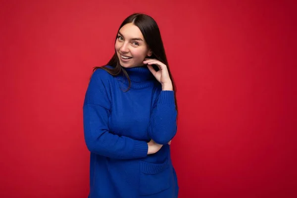 Mladá atraktivní brunetka žena s upřímnými emocemi izolované na pozadí zdi s kopírovací prostor na sobě ležérní trendy modrý svetr. Happy concept — Stock fotografie