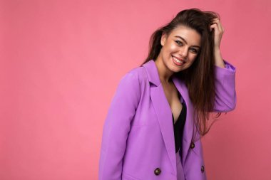 Genç, pozitif esmer, güzel görünümlü, çekici, zarif, modaya uygun, pembe renkli arka plan üzerinde izole edilmiş, mesaj için boş alan olan bir kadın.