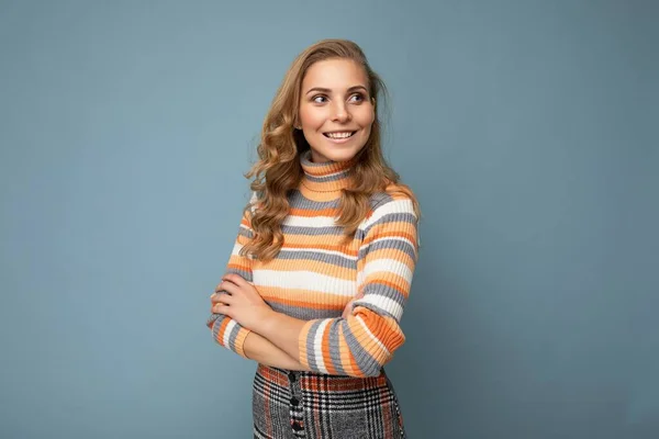 Retrato de jovem winsome atraente feliz sorrindo mulher loira com cabelo ondulado vestindo camisola listrada isolado sobre fundo azul com espaço vazio — Fotografia de Stock