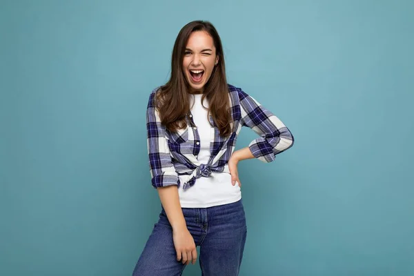 Jeune belle femme brune. Dame à la mode en t-shirt tendance d'été. Femme positive montre le visage émotions sincères. Modèle drôle isolé sur fond bleu avec espace libre — Photo