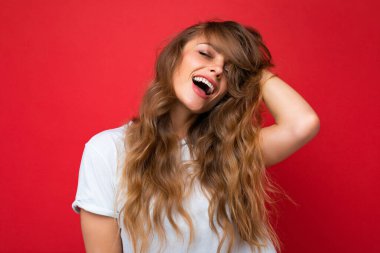 Güzel görünümlü, sevimli, sevimli, sevimli, sevimli, güzel, neşeli, neşeli, dalgalı saçlı, sarışının yakın plan portresi. Pastel arka planda izole edilmiş, şık kıyafetler giyiyor.