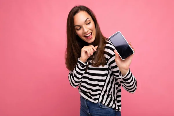 우스꽝 스러운 성인 여성 이 줄무늬 스웨터를 입은 모습, 사진 복사 공간에서 핸드폰 화면을 보며 격리 된 모습 — 스톡 사진