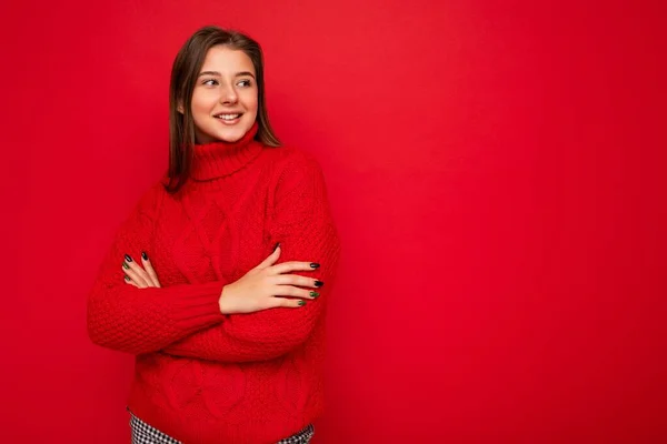 Aufnahme einer attraktiven, glücklich lächelnden jungen Frau in lässigem Outfit, die isoliert vor buntem Hintergrund steht und zur Seite schaut — Stockfoto