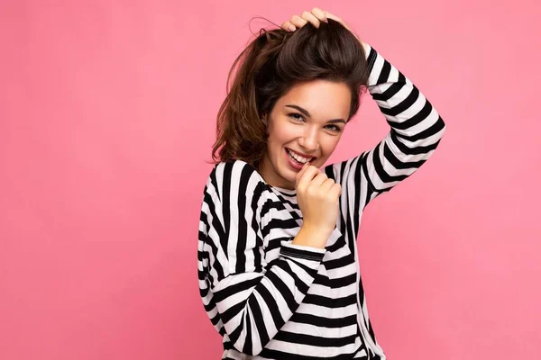 Фотографічний портрет молодої красивої усміхненої жінки-гіпстера в модному пуловері. Сексуальна безтурботна жінка позує ізольована біля рожевої стіни з порожнім простором в студії. Позитивна модель з натуральним — стокове фото