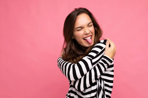 Foto záběr roztomilé atraktivní hezká mladá šťastná radostná bruneta žena na sobě ležérní pruhované dlouhé rukávy izolované přes barevné pozadí s kopírovacím prostorem a ukazující jazyk — Stock fotografie