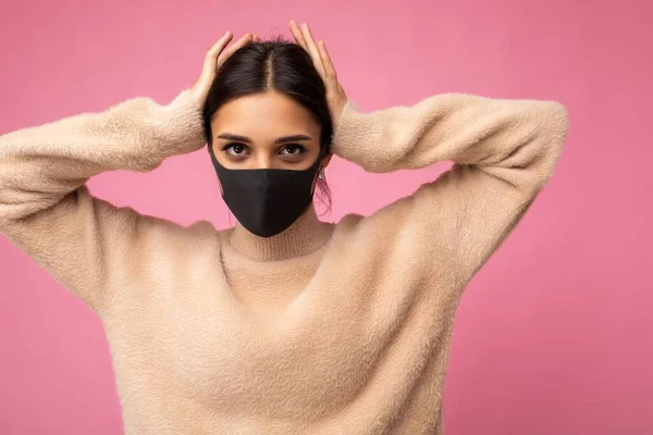 Mladá žena na sobě antivirové ochranné masky, aby se zabránilo ostatním z korony COVID-19 a SARS cov 2 infekce izolované přes růžové pozadí — Stock fotografie