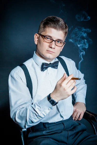 Successful young man smoking a cigar — Stock Photo, Image