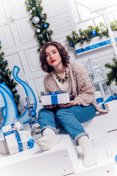 Genç ve güzel kız kot pantolon ve Noel hediyeleri ile bir hırka — Stok fotoğraf