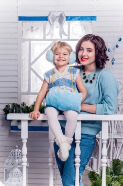 Chr yanında duran büyük kız kardeşi ile gülümseyen küçük kız