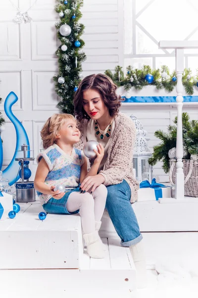 Niños al lado de un árbol de Navidad se dan regalos . — Foto de Stock