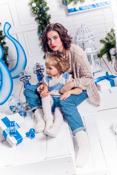 Ragazza seduta con sua sorella vicino a un albero di Natale e sorridente — Foto Stock