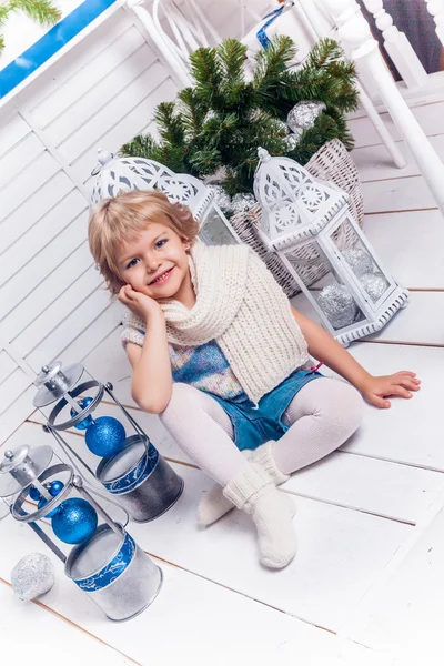 Petite jolie fille assise à côté d'un arbre de Noël et de Noël — Photo