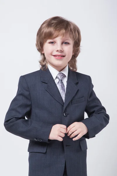 Niño en un traje clásico endereza su chaqueta —  Fotos de Stock