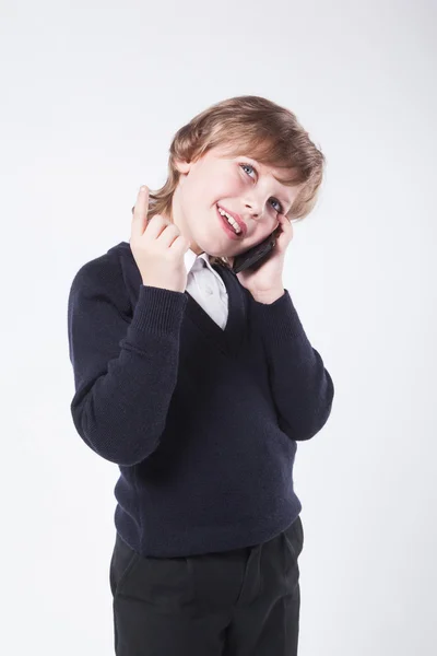 Young businessman in a blue sweater talking on the phone and smi — Stock Photo, Image