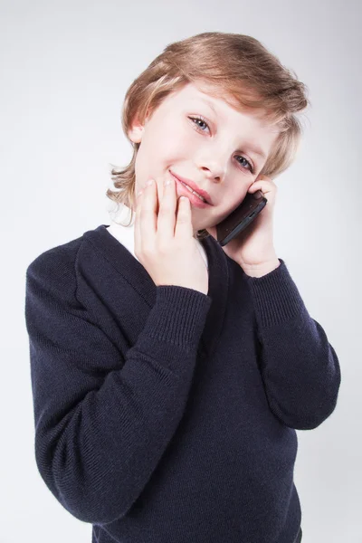 Joven hombre de negocios en un suéter azul hablando por teléfono y smi —  Fotos de Stock