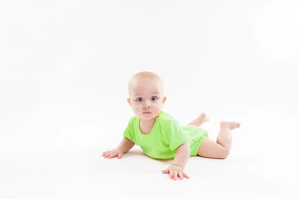 Cute curious baby lies on her stomach and looking at the camera — Stock Photo, Image