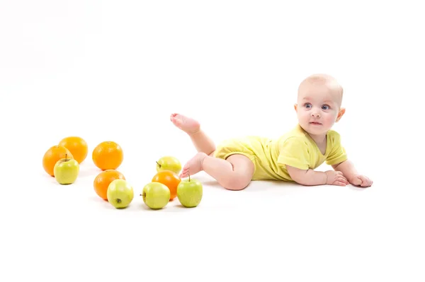 Ładny zaskoczony dziecko patrzy na zielone jabłko na białym tle — Zdjęcie stockowe