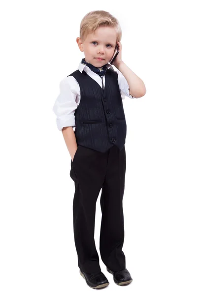Petit écolier sur un fond blanc parlant au téléphone — Photo