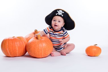 Beautiful baby in a striped T-shirt and a pirate hat on a white