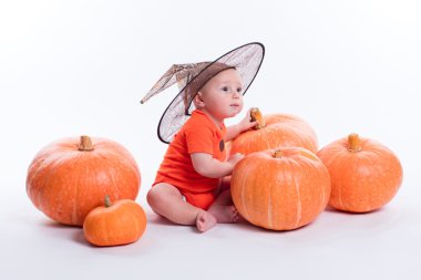 Baby in orange t-shirt on a white background sitting in a witche