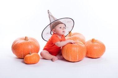 Baby in orange t-shirt on a white background sitting in a witche