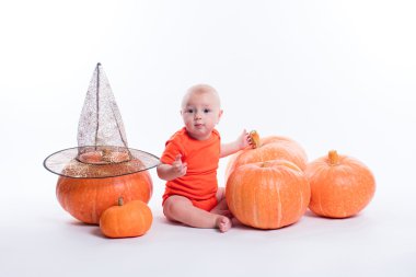 Baby in orange t-shirt sitting on a white background surrounded