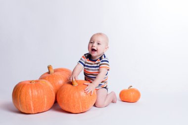 Beautiful baby in a striped shirt on white background sitting on