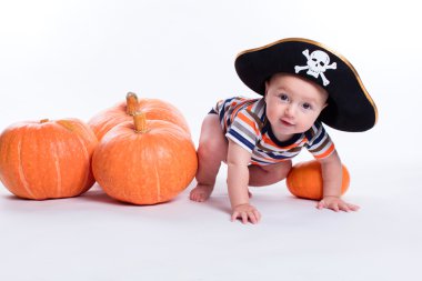Beautiful baby in a striped T-shirt and a pirate hat on a white