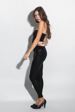 Charming young student on a white background in a black tight pa