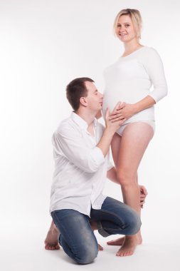 young dad in jeans and a white shirt kissing in the stomach knee