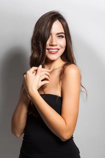 Student smiling brunette with white teeth on a white background — Stock fotografie