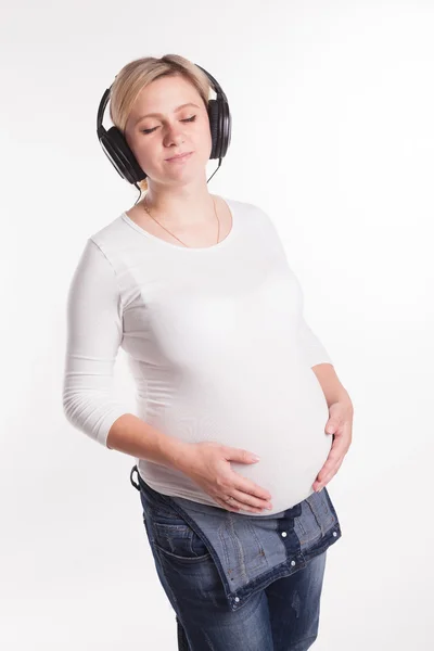 Pregnant blonde in jeans and a white t-shirt on a white backgrou — Stock Photo, Image