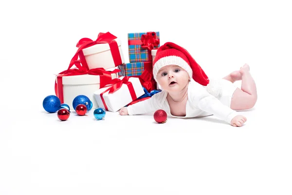 Bébé mignon dans une casquette rouge du Nouvel An avec un sourire sur son visage couché — Photo