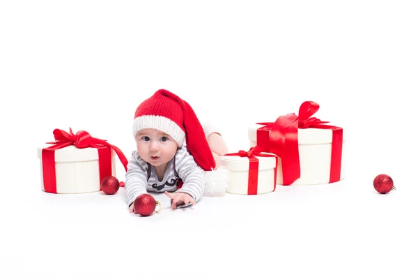 Bébé mignon dans une casquette rouge du Nouvel An avec un sourire sur son visage couché — Photo