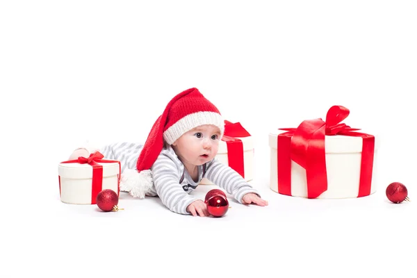 Bébé mignon dans une casquette rouge du Nouvel An avec un sourire sur son visage couché — Photo