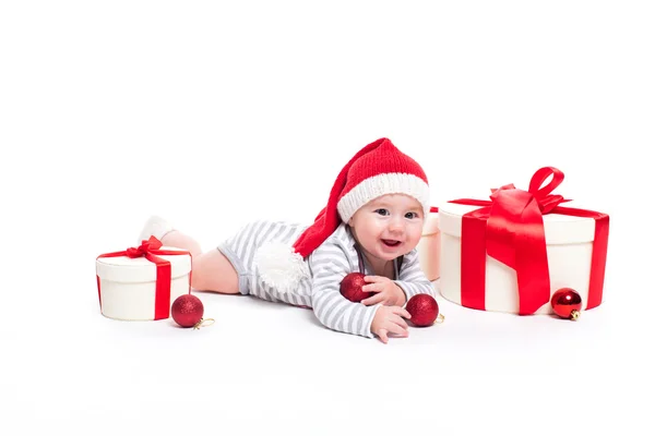 Bébé mignon dans une casquette rouge du Nouvel An avec un sourire sur son visage couché — Photo