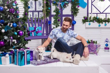 beautiful man sitting on a terrace next to a Christmas with a Ch