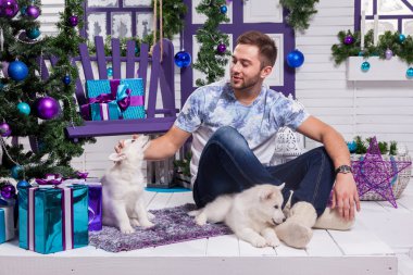 beautiful man sitting on a terrace next to a Christmas with a Ch