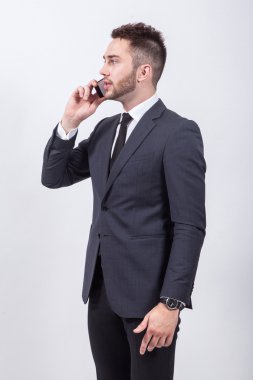 successful young student in a classic stylish suit talking on th