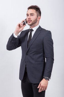 successful young student in a classic stylish suit talking on th